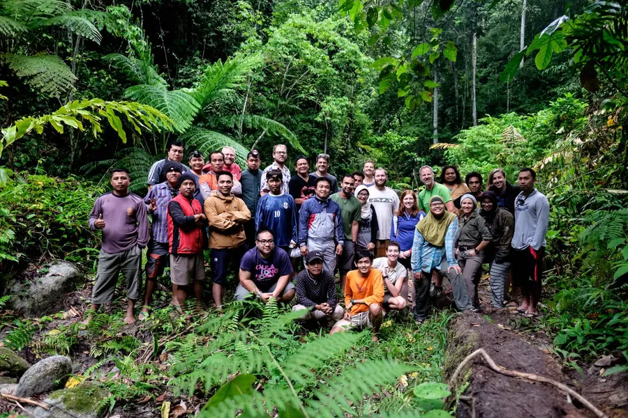 Expedition team of collaborators, local community members, and students in the rainforest