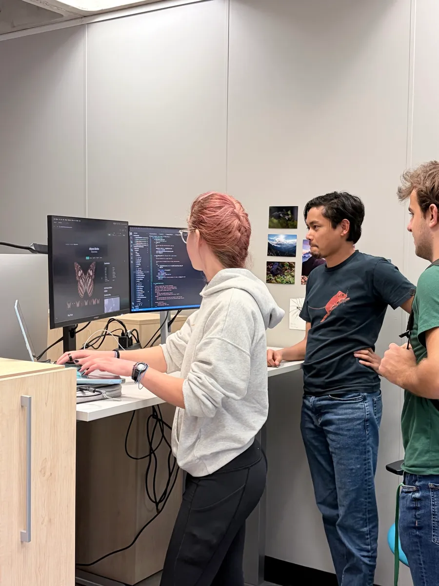 Heru and a student reviewing butterfly image analysis code
